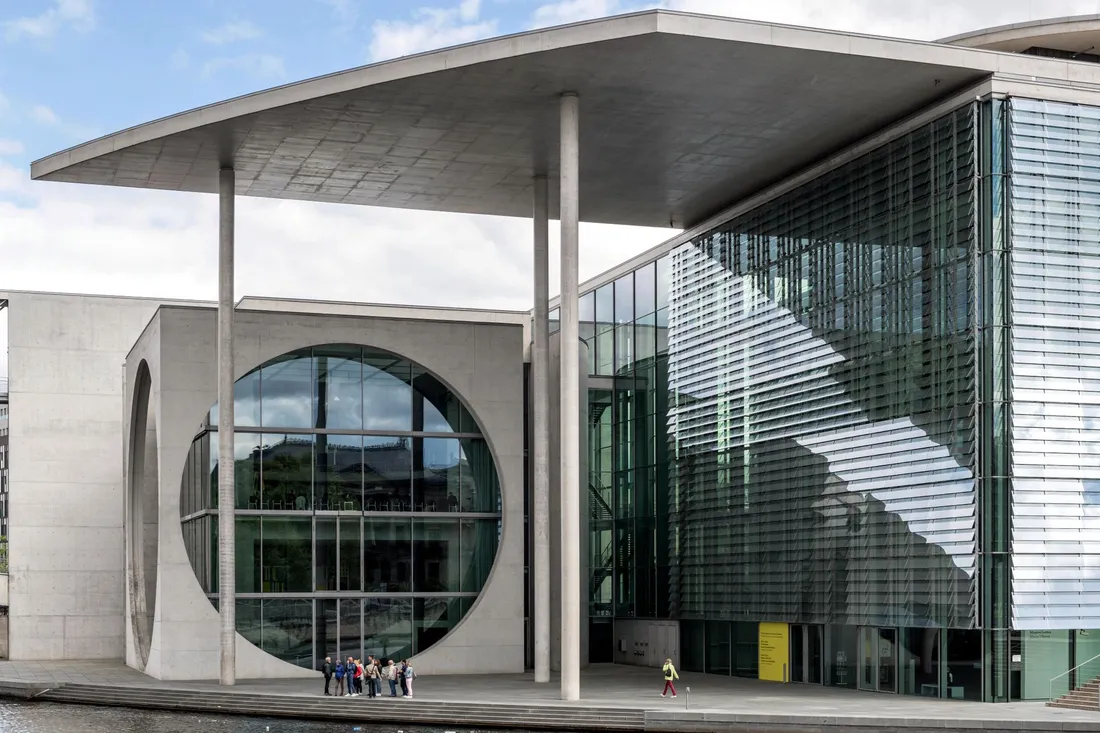 Moderner Betonbau mit großem Rundfenster und Glasfassade direkt am Flussufer